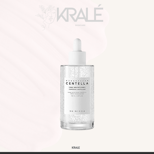 Frasco de sérum facial Skin1004 Madagascar Centella Tone Brightening Capsule Ampoule con gotero sobre fondo claro con logo KRALÉ