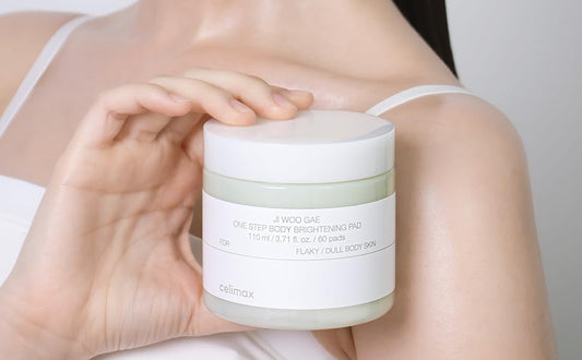 Discos de algodón exfoliantes Celimax Jiwoogae One Step Body Brightening Pad mostrados en frasco sobre mano